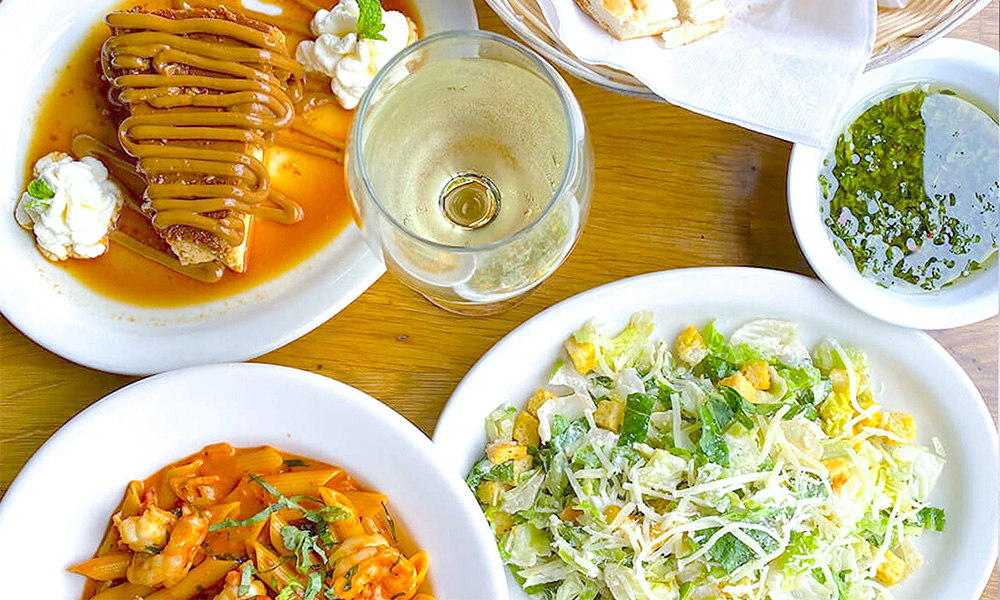 shrimp pasta, caesar salad, and a flan